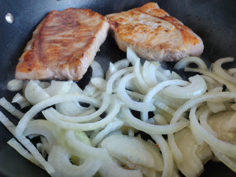 Pork  chop and onions cooking in the pan
