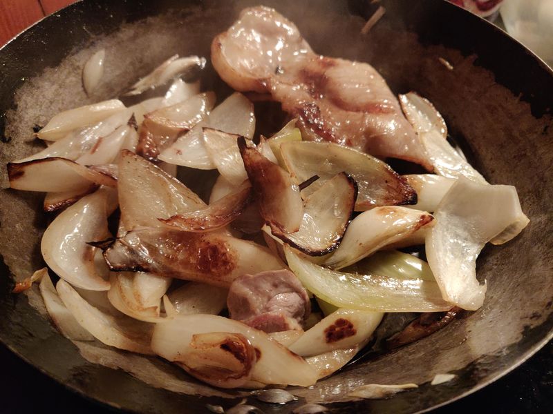 Onions cooking in skin fat